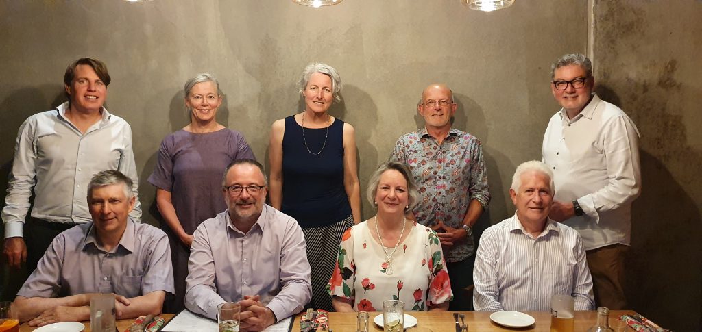 Nexus Volunteer Board and CEO gathered at a restaurant table to celebrate a successful and challenging year.