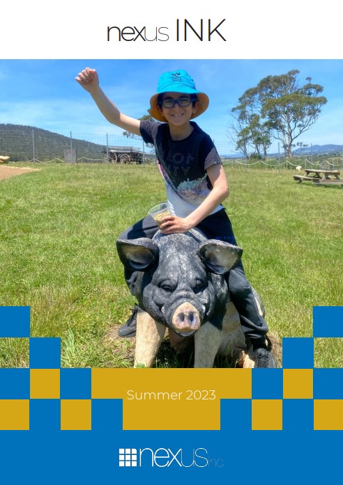 A smiling, young boy sits on top of a large pig sculpture at animal farm Zoodoo.