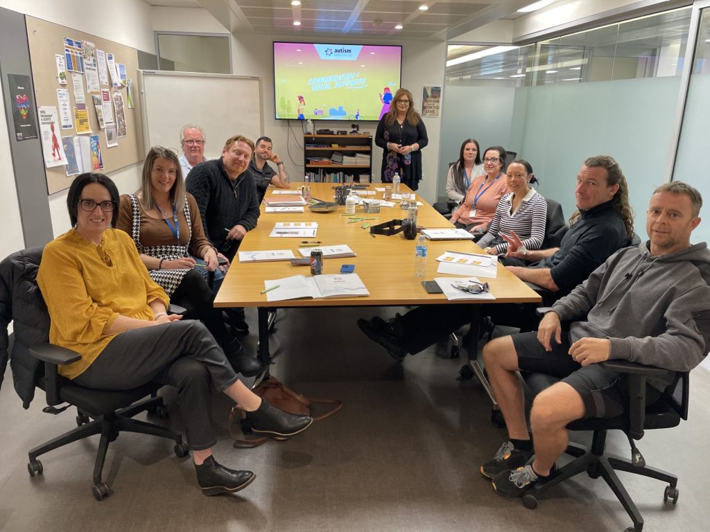 Ten Nexus staff and an Autism Tasmania representative sit around the table, ready to commence an autism-specific training session.